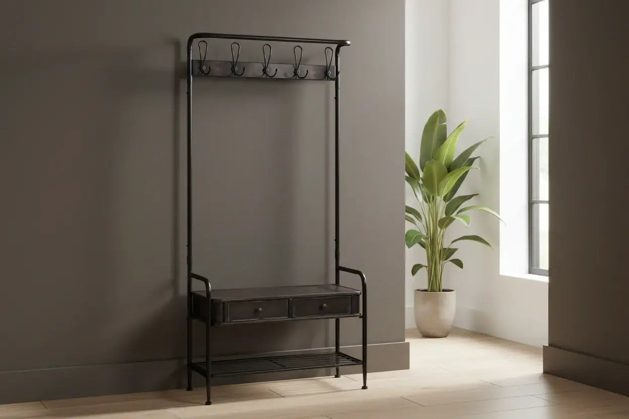 Black metal hall stand with hooks and a small drawer against a neutral wall with a plant in the background.