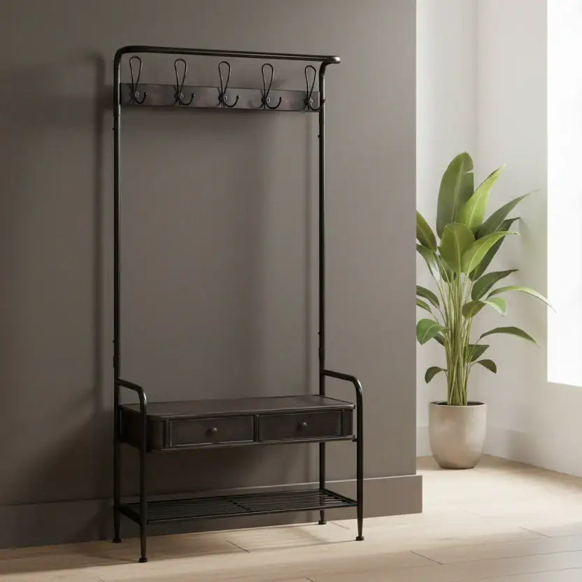 Black metal coat rack with a small table and hooks against a neutral wall with a plant.