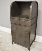 Metal cabinet with a drawer against a gray wall