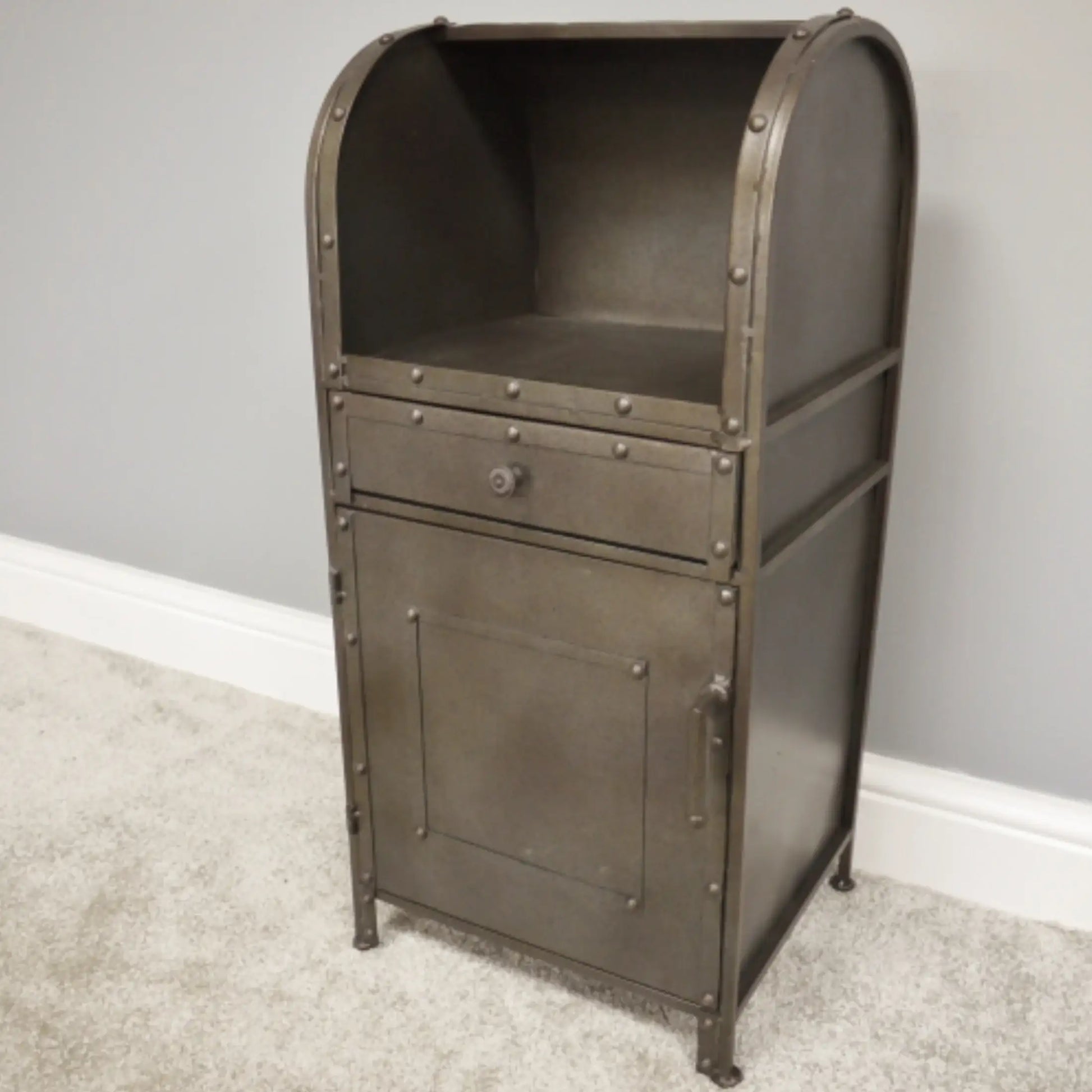 Metal cabinet with a drawer against a gray wall