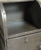 Metallic cylindrical object with riveted details on a wooden background