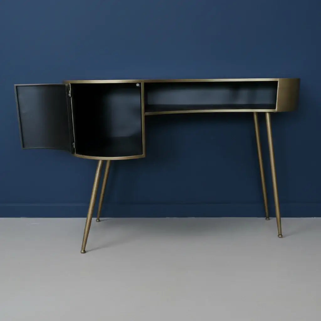 Modern black desk with gold legs against a blue wall