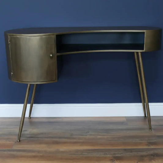 Bronze desk with a black shelf against a gray wall.