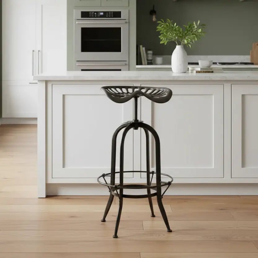 Black metal bar stool in a modern kitchen with white cabinets and wooden floor.