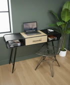 Modern desk with laptop, chair, and plant in a room with green walls and wooden floor.