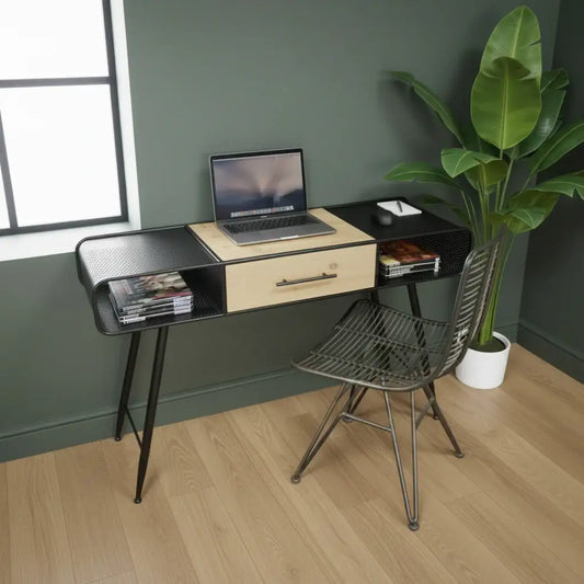 Modern desk with laptop, chair, and plant in a room with green walls and wooden floor.