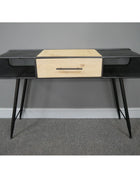 Modern console table with black metal frame and wooden drawer against a gray wall.