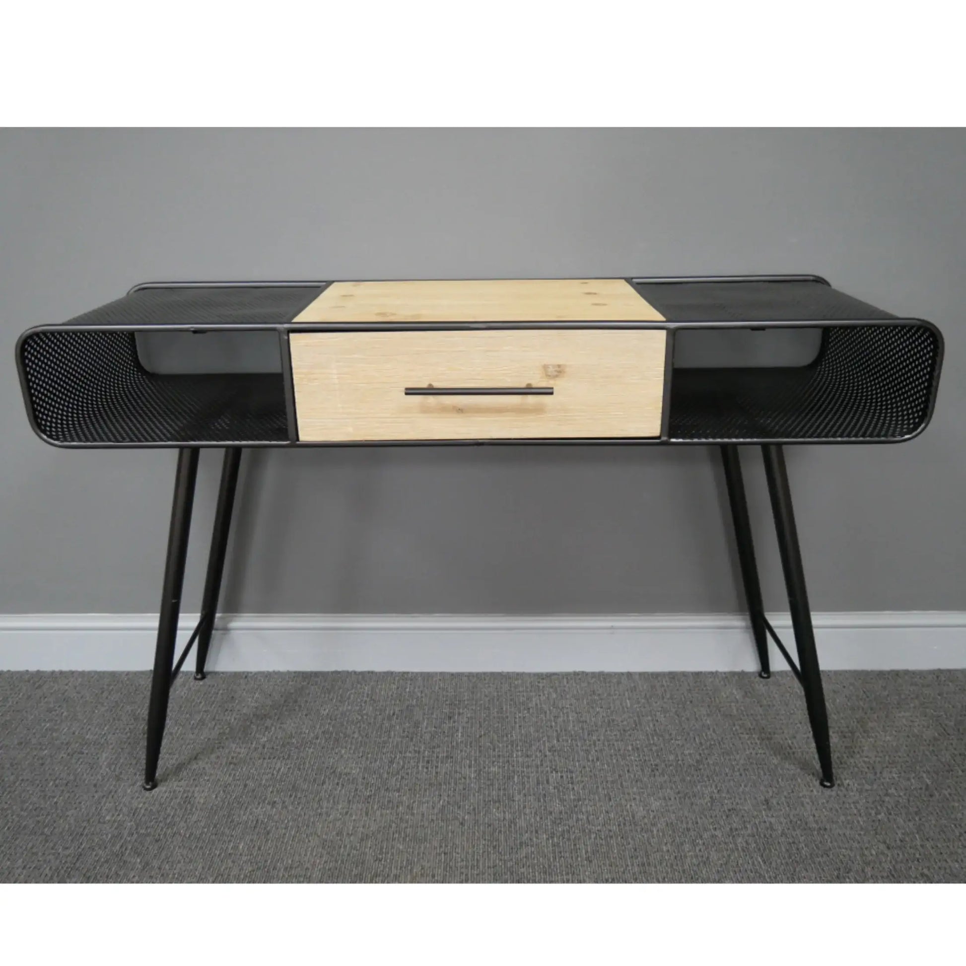 Modern console table with black metal frame and wooden drawer against a gray wall.