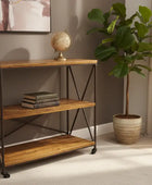 Wooden shelf with books and a plant in a room with a window and painting.