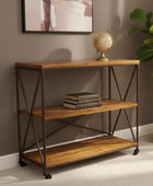 Wooden console table with metal legs against a wall with a framed picture and plant.
