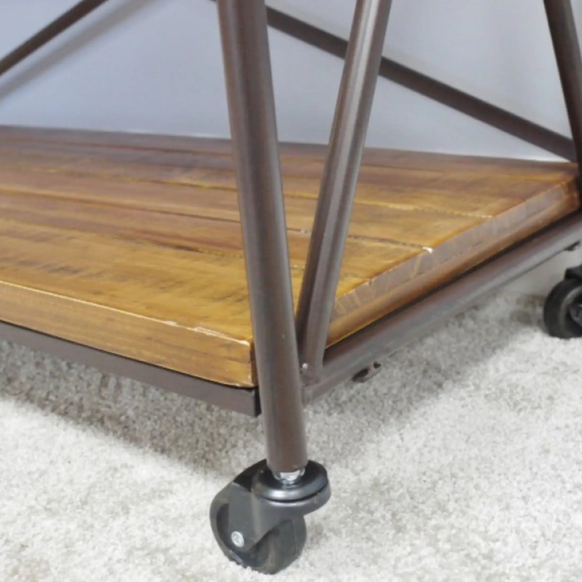 Wooden shelf with metal frame and wheels on a carpeted floor