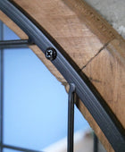 Close-up of a wooden shelf with metal brackets against a blurred background