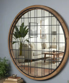 Round wall mirror with grid design in a living room setting