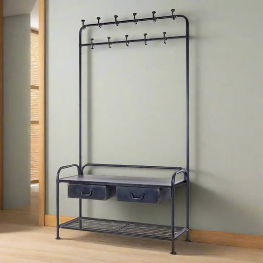 Black metal coat rack with hooks and a shelf against a light green wall.