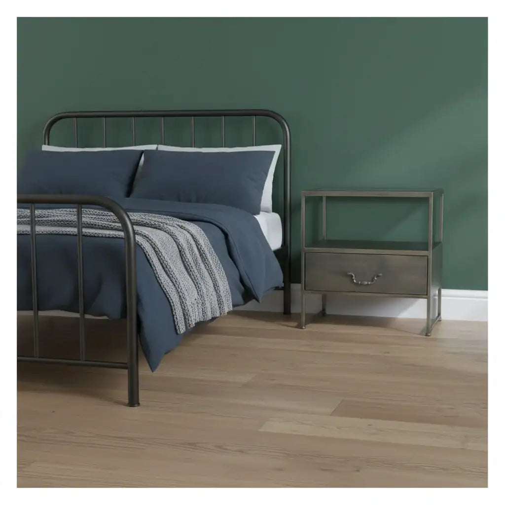 Bedroom with a metal bed frame, blue bedding, and a nightstand against a green wall.