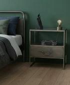 Bedroom with a bed and nightstand against a green wall