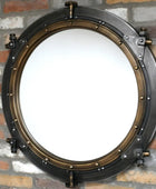 Round metallic mirror with a vintage design on a brick wall