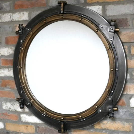 Round metallic mirror with a vintage design on a brick wall