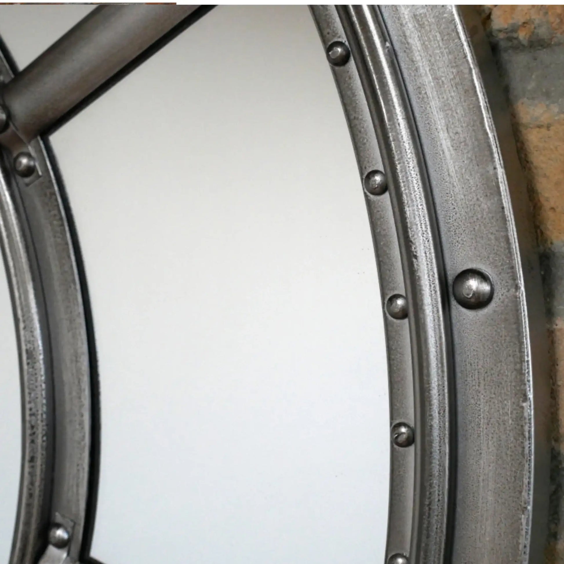 Close-up of a metal wheel rim with rivets on a white background