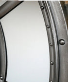Close-up of a metal wheel rim with rivets on a white background