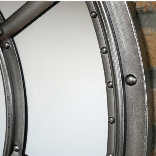 Close-up of a metal wheel rim with rivets on a white background