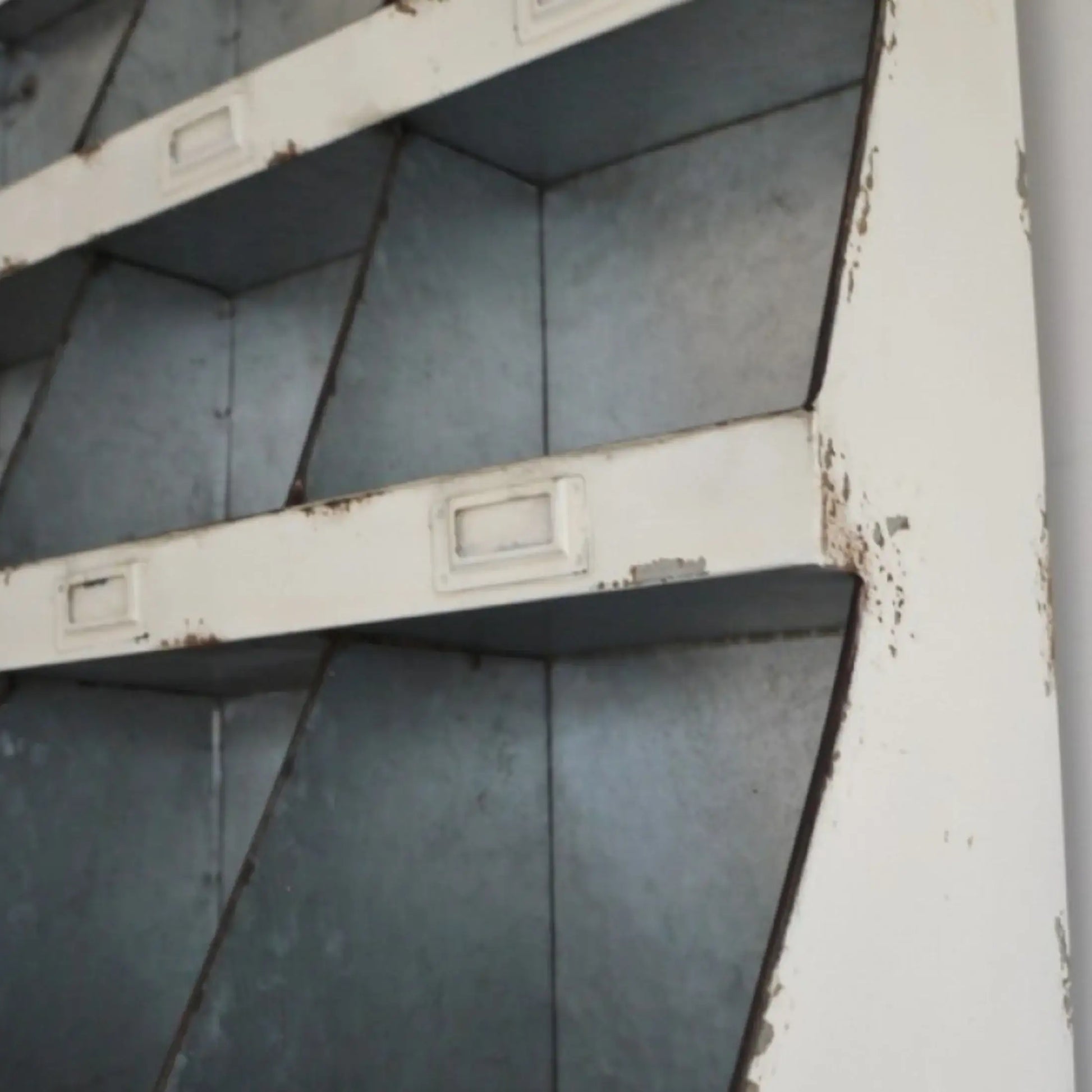 Rust-covered metal shelves in a corner with peeling paint.