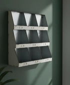 Wall-mounted metal shelf with geometric design on a green wall