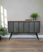 Modern sideboard with metallic doors in a room with plants and wooden flooring.