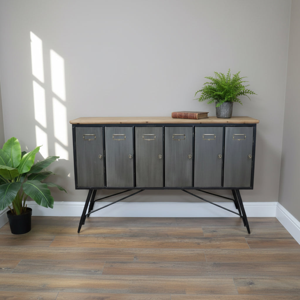 Modern sideboard with metallic doors in a room with plants and wooden flooring.