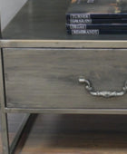 Metallic nightstand with a drawer and books on top
