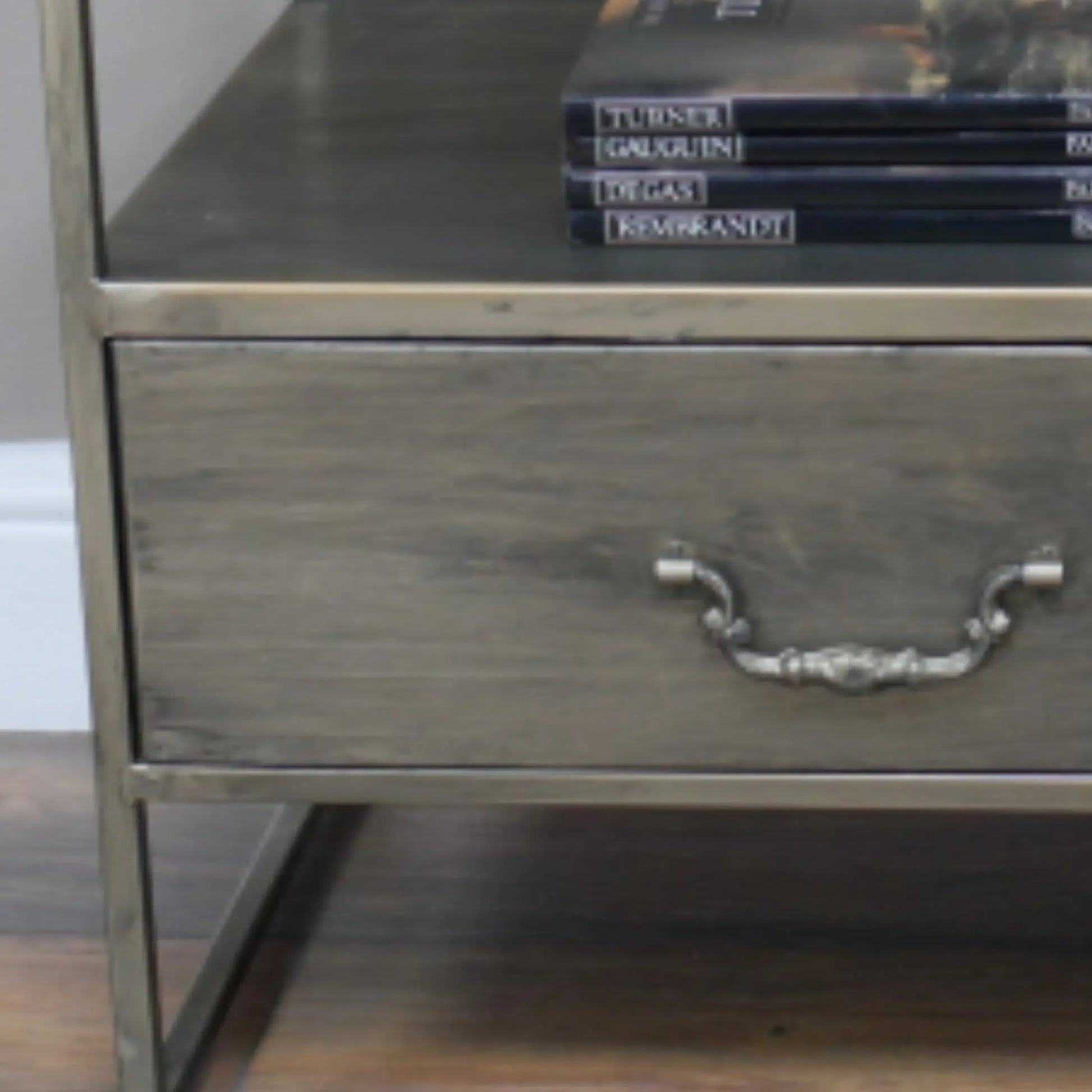 Metallic nightstand with a drawer and books on top