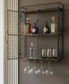 Wall-mounted metal cabinet with liquor bottles and glasses on a neutral background