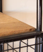 Close-up of a chair with a wooden seat and black metal frame.