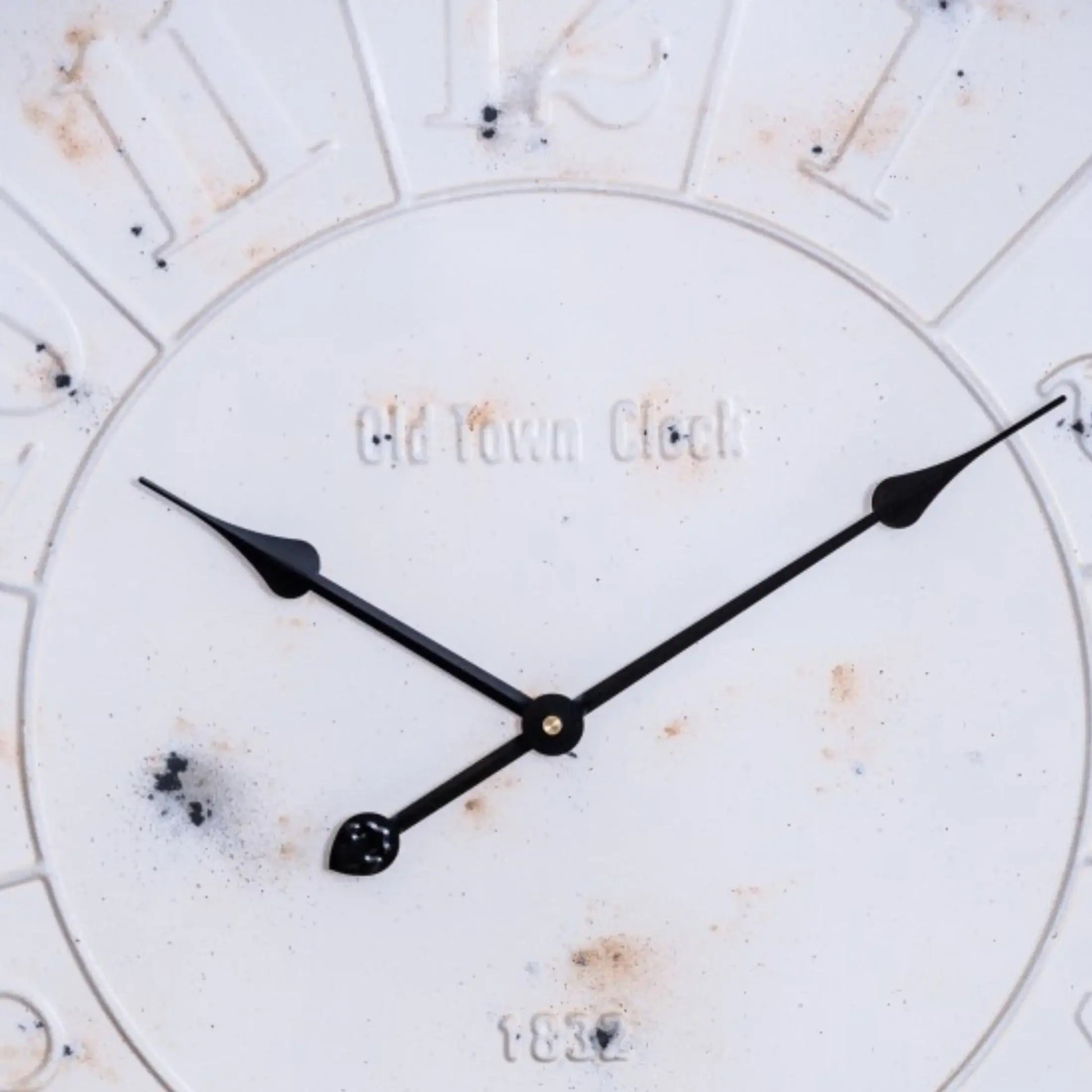 Close-up of a clock face with 'Old Town Clock' branding on a white background