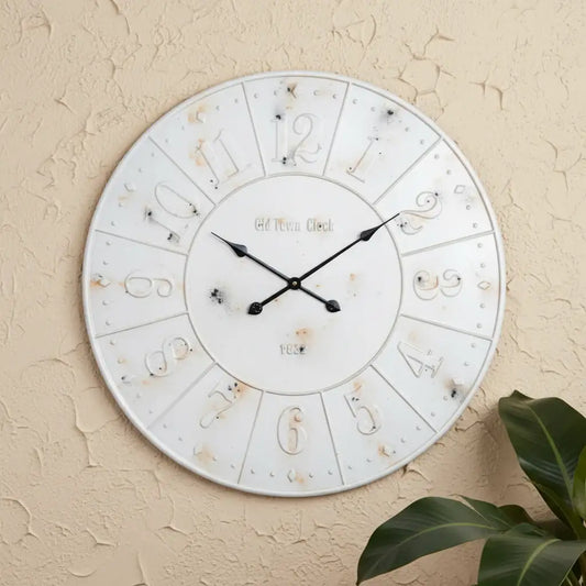 Decorative wall clock with black hands on a beige wall