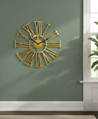 Gold wall clock on a green wall with a plant in the corner