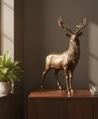 Bronze deer statue on a wooden cabinet with a plant and books in the background