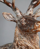 Bronze deer statue with detailed antlers on a gray background
