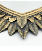 Close-up of a gold and silver leaf-patterned necklace on a white background
