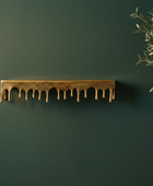 Decorative gold shelf with plants against a dark green wall