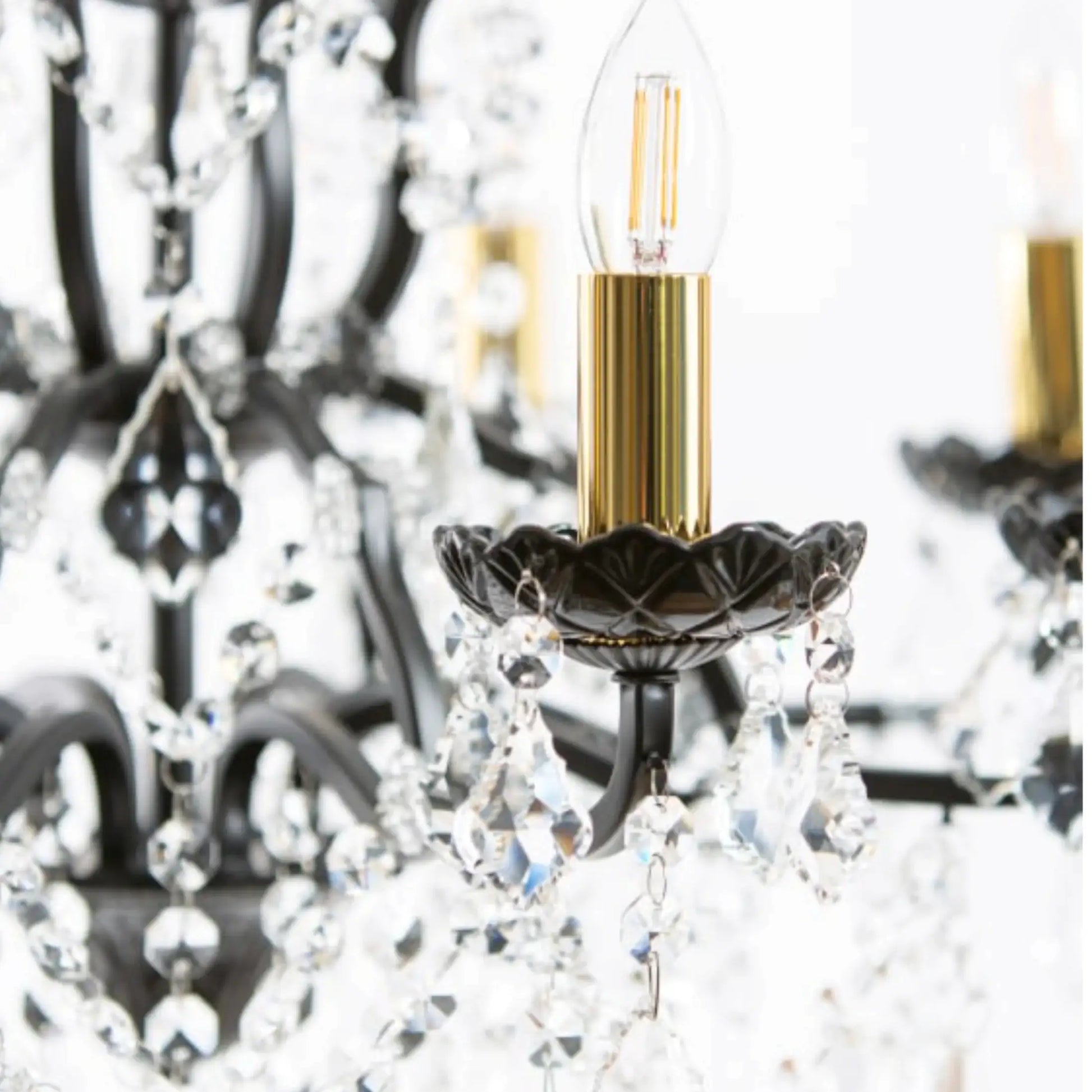 Close-up of a chandelier with a lit LED bulb inside, blurred background