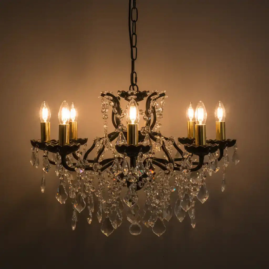 Crystal chandelier with six lit candles against a dark background