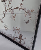 A framed wall art print featuring delicate cherry blossom branches with pale pink flowers, brown leaves, birds perched on branches, and a butterfly on an off-white background.