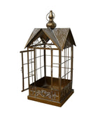 Decorative metal birdcage with a roof on a wooden surface