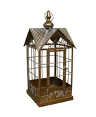 Decorative metal birdcage on a wooden surface with a white background