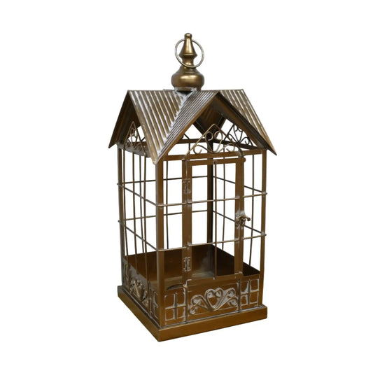 Decorative metal birdcage on a wooden surface with a white background