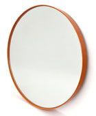 An oval wall mirror with a warm orange-brown wooden frame, shown at a slight angle against a plain white background.