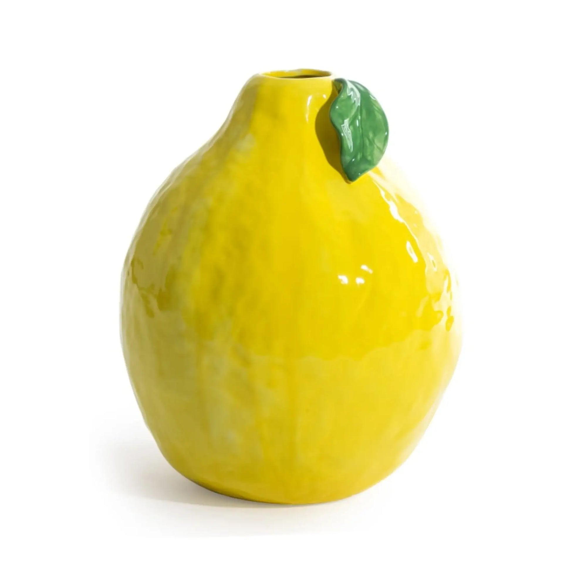 Yellow ceramic lemon-shaped vase with a green leaf on a white background