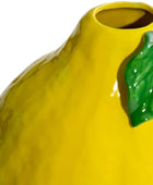 Yellow ceramic vase with a green leaf on a white background
