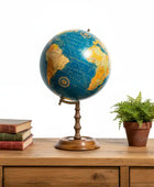 Globe on a wooden table with books and a plant
